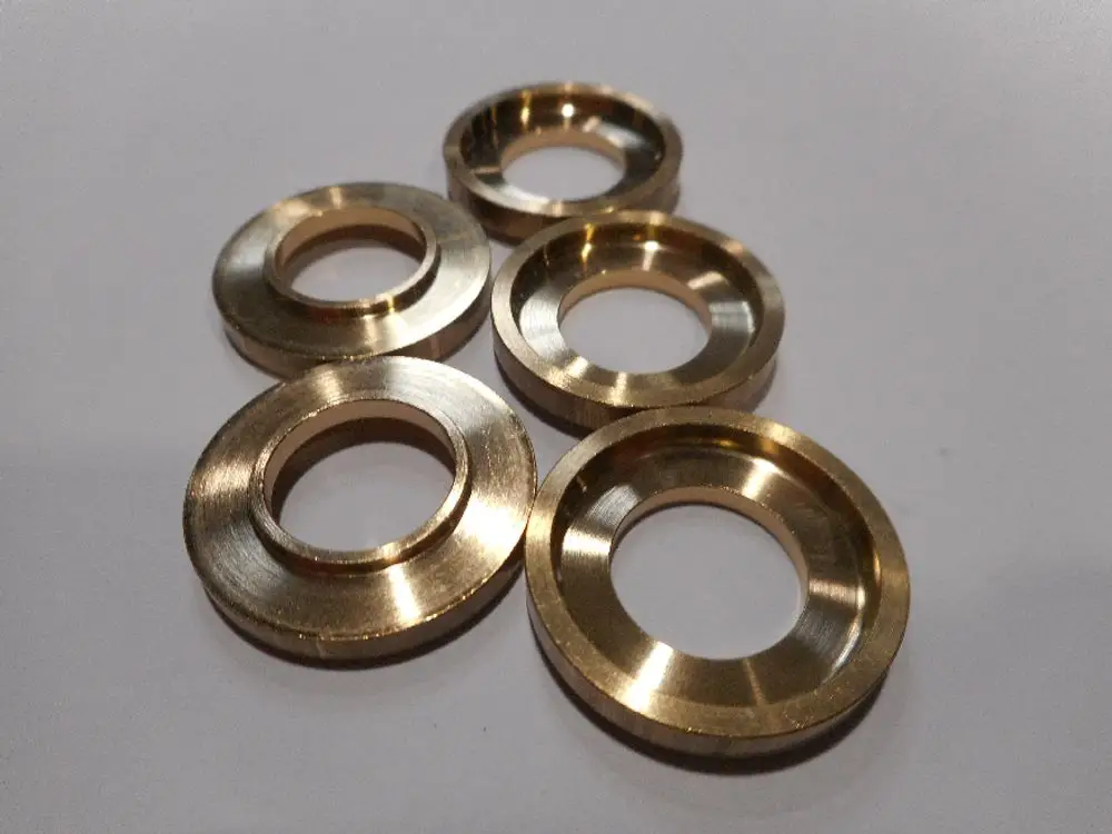 Set aus runden Metallzwischenstücken in Goldfarbe. Remeha Komponenten, die typischerweise in technischen Anwendungen oder Maschinen verwendet werden.